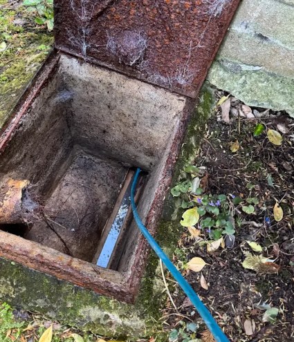 A blocked sewer drain being unblocked for a client